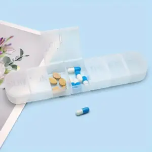Hvítt pillubox fyrir vikuna, opið með hylkjum og töflum