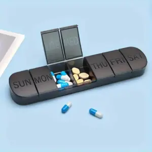 Svart pillubox fyrir vikuna, opið með hylkjum og töflum